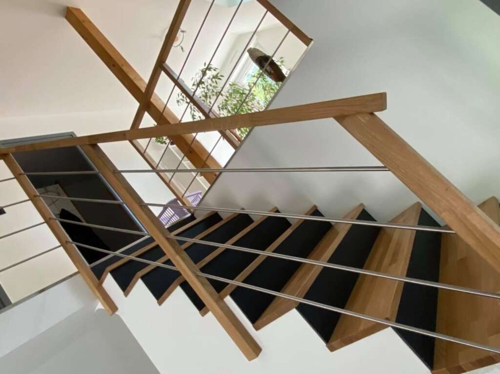 Escalier en chêne massif avec contremarches noires et garde-corps bois