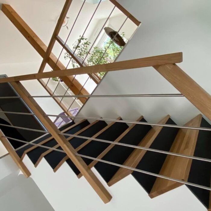 Escalier en chêne massif avec contremarches noires et garde-corps bois