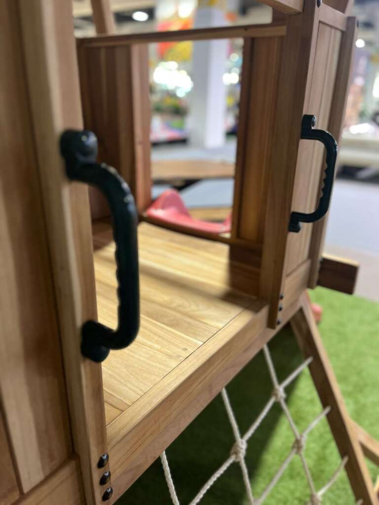 Vue latérale d’une aire de jeux en teck avec accès par cordage